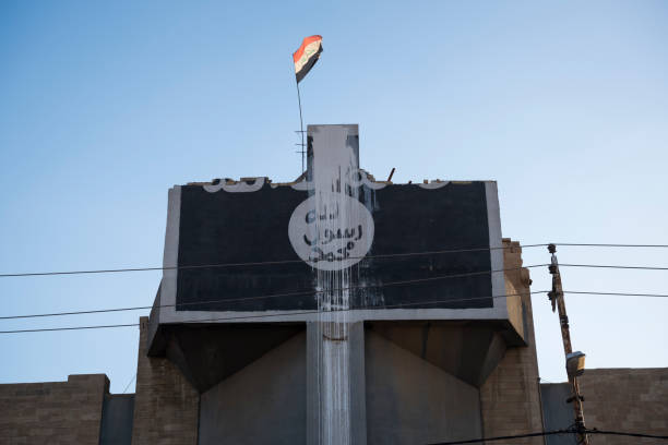 Damaged Syriac Orthodox Church of St. Ephraim in Mosul, Iraq An Iraqi flag flies from the top of the heavily damaged Church of St. Ephraim, a Syriac Orthodox church, in Mosul, Iraq, in the months after this part of Mosul was taken from ISIS. The ISIS emblem was painted on the front of the building during the ISIS occupation of Mosul. militant groups photos stock pictures, royalty-free photos & images