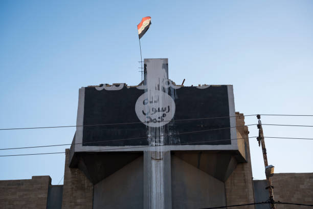 Damaged Syriac Orthodox Church of St. Ephraim in Mosul, Iraq An Iraqi flag flies from the top of the heavily damaged Church of St. Ephraim, a Syriac Orthodox church, in Mosul, Iraq, in the months after this part of Mosul was taken from ISIS. The ISIS emblem was painted on the front of the building during the ISIS occupation of Mosul. militant groups stock pictures, royalty-free photos & images