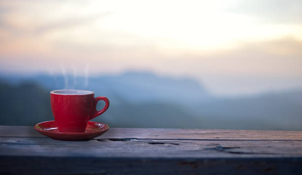 赤日光山風景をテーブルの上のコーヒー カップ。美しさ、自然の背景 - hot drink tea black tea red ストックフォトと画像