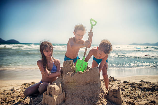 istock Kids are building sandcastle on a beach 690793568