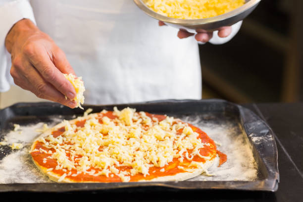 istock Closeup mid section of a male chef preparing pizza in kitchen 690793960