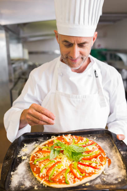 istock Confident chef holding cooked food in kitchen 690794286
