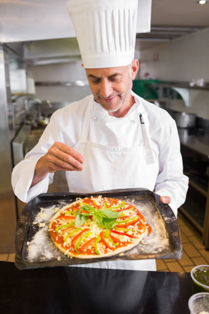 istock Confident male chef holding cooked food in kitchen 690796080