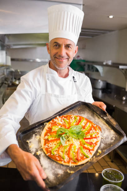 istock Confident chef holding cooked food in kitchen 690796148