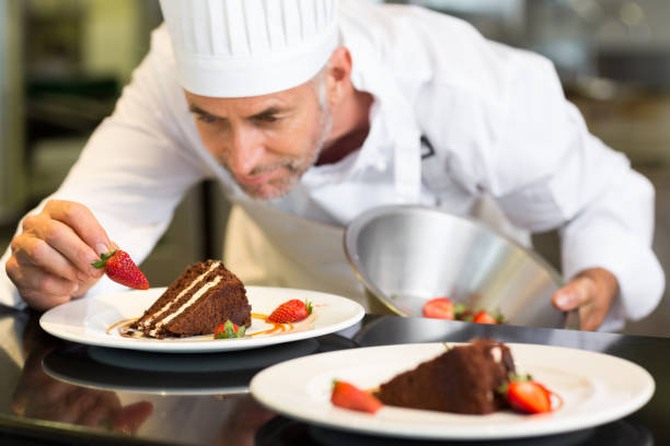 istock Concentrated male pastry chef decorating dessert 690796576