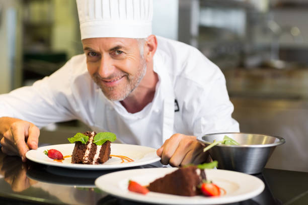istock Smiling male pastry chef with dessert in kitchen 690796682