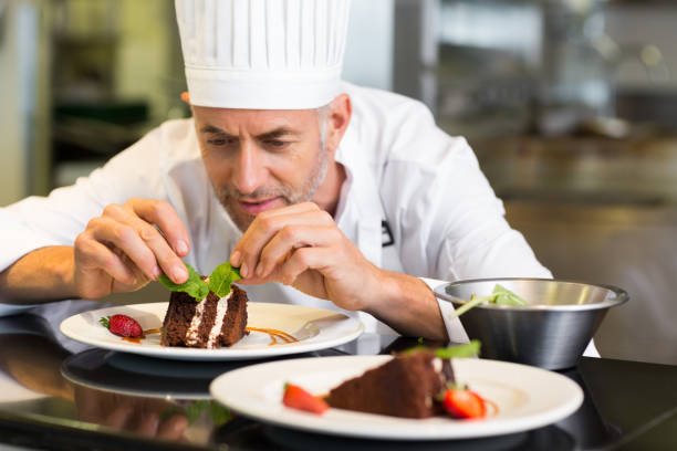 istock Concentrated male pastry chef decorating dessert in kitchen 690796690