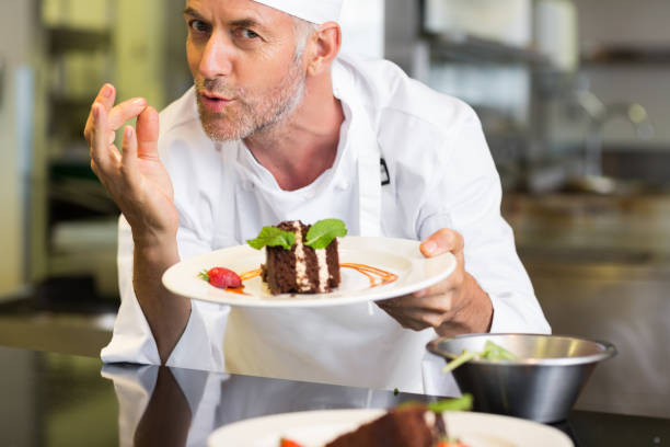istock Smiling male pastry chef with dessert in kitchen 690796706