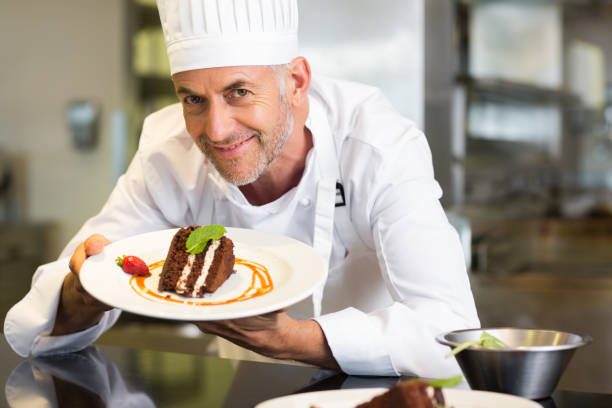 istock Smiling male pastry chef with dessert in kitchen 690796744