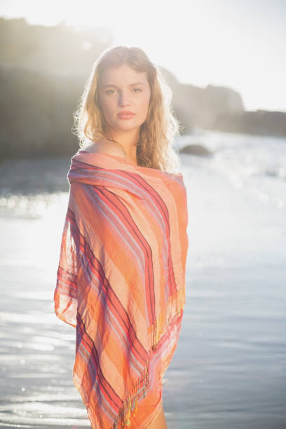 istock Beautiful blonde wrapped in scarf at the beach 690797088