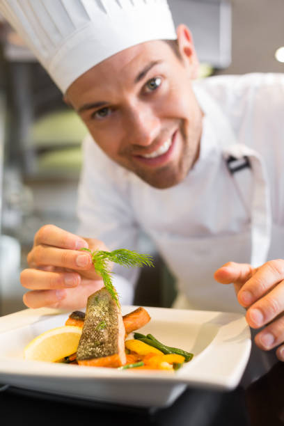 istock Smiling male chef garnishing food in kitchen 690797606