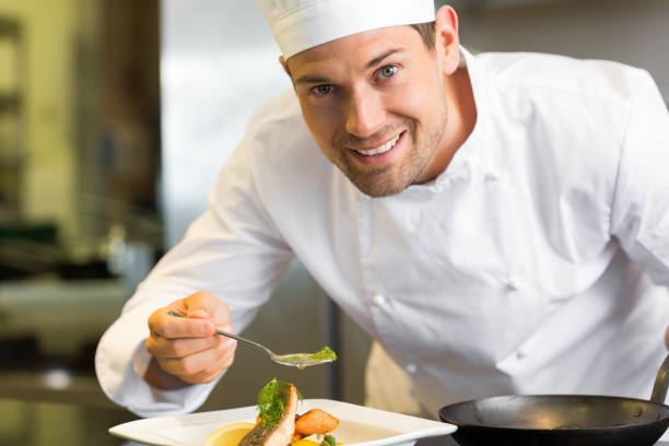 istock Smiling male chef garnishing food in kitchen 690797720