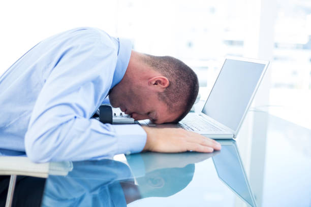 istock Tired businessman resting on laptop 690797784