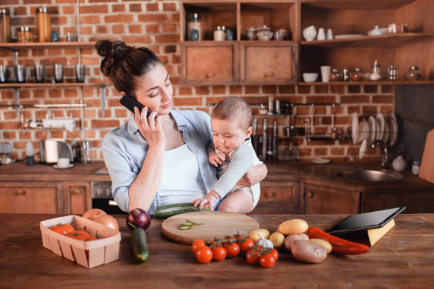 istock mother with son talking on smartphone and preparing dinner 690826172