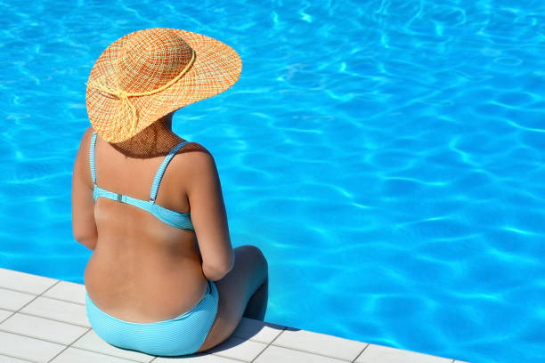 istock Real female beauty relaxing at swimming pool 690826300
