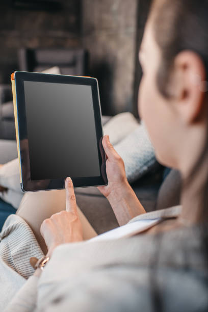 istock woman pointing on blank screen of digital tablet 690829192