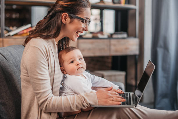 istock mother with her son using laptop at home 690829432