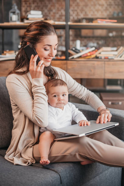 istock Mother smiling and working at home while taking care of her son 690832650