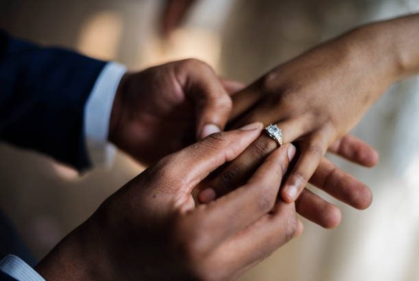 groom put on wedding ring bride hand - engagement ring imagens e fotografias de stock
