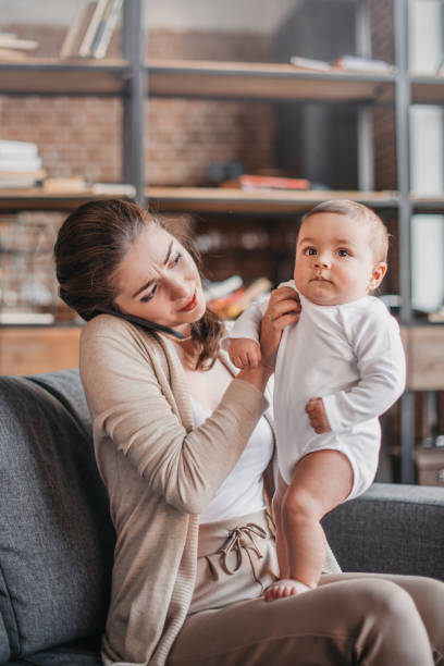 istock woman talking on smartphone and spending time with her son at home 690834578