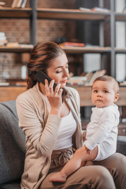 istock woman talking on smartphone and spending time with her son at home 690837156