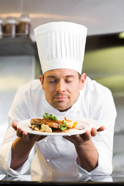 istock Male chef with eyes closed smelling food in kitchen 690838000