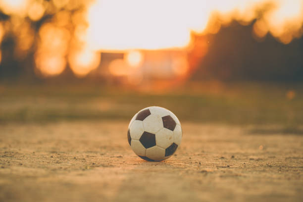 夕日の光線の光の下でストリート サッカー サッカー ボール。 - soccer field dirty soccer outdoors ストックフォトと画像