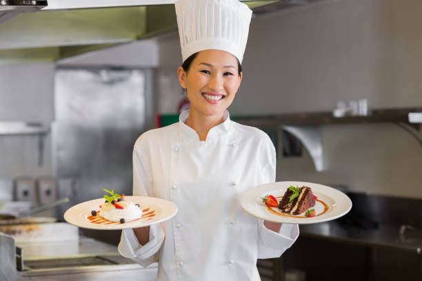 istock Confident female chef holding cooked food in kitchen 690840558