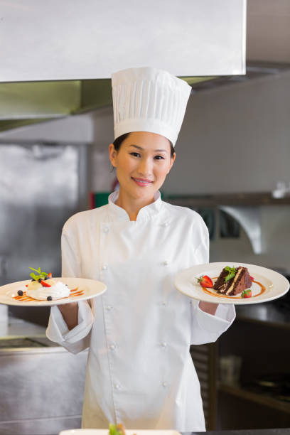istock Confident female chef holding cooked food in kitchen 690840576
