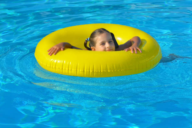 Adorable toddler relaxing in swimming pool, summer vacation concept