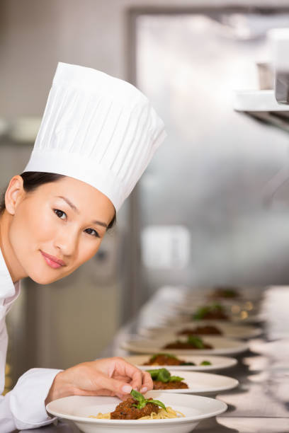 istock Smiling female chef garnishing food in kitchen 690841320