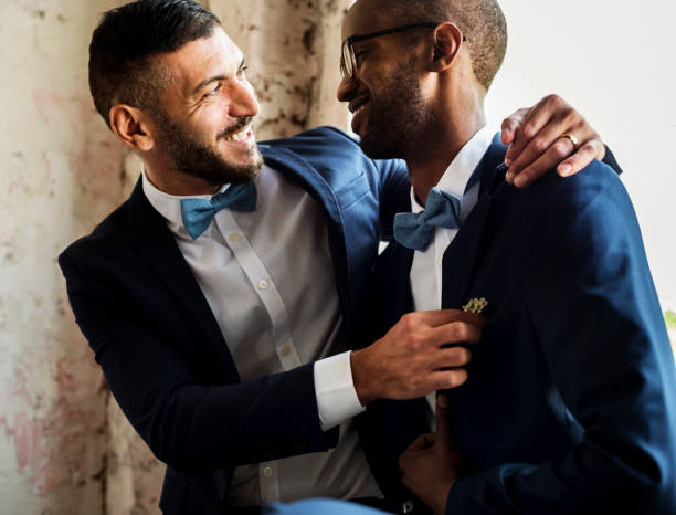 гей пара обнимая друг друга - homosexual стоковые фото и изображения