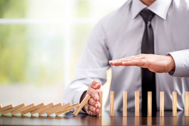 Protecting Assets From Domino Effect. Stop Loss Concept. Protecting Assets From Domino Effect. Stop Loss Concept For Stock Exchange Market. hand stopping dominos stock pictures, royalty-free photos & images