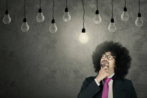 istock Afro businessman looking at light bulb 690853422