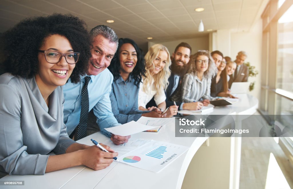 Cheerful multiracial colleagues looking at camera in office Smiling black and white coworkers looking at camera in the office. Teamwork Stock Photo