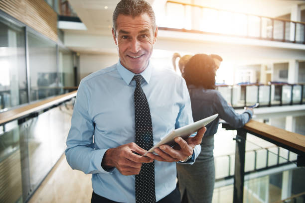 istock Cheerful businessman with tablet looking at camera 690855916