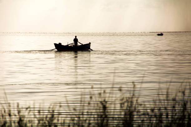 istock Fishermen Boat Sunset Lagoon 690859756