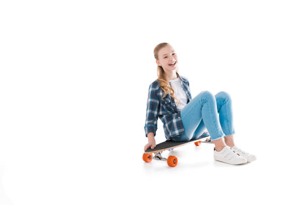 istock happy girl sitting on skateboard isolated on white in studio 690868120