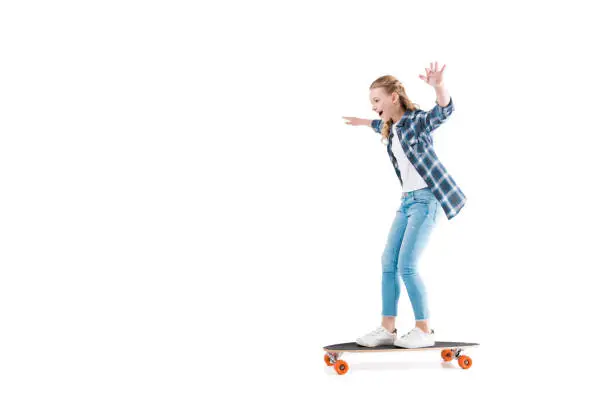 adorable happy girl with skateboard isolated on white in studio