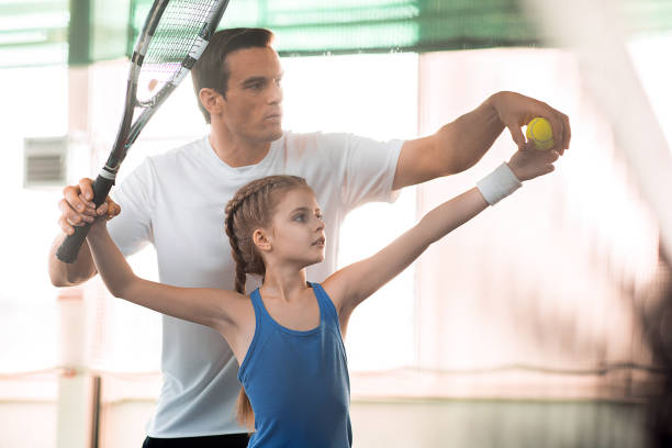 istock Active family playing tennis on court 690878932