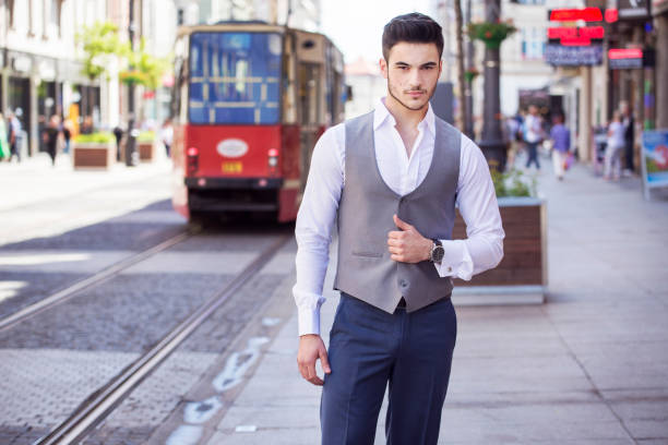 apuesto hombre de negocios vestido elegantemente, caminando por la ciudad - smartly fotografías e imágenes de stock