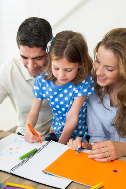istock Parents and daughter coloring 690879308