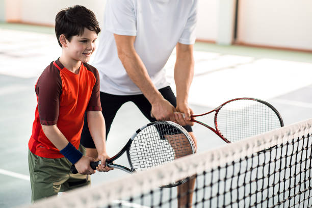 istock Joyful kid playing tennis with father 690879412