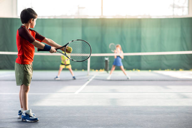 istock Concentrated boy pitching tennis ball 690879970