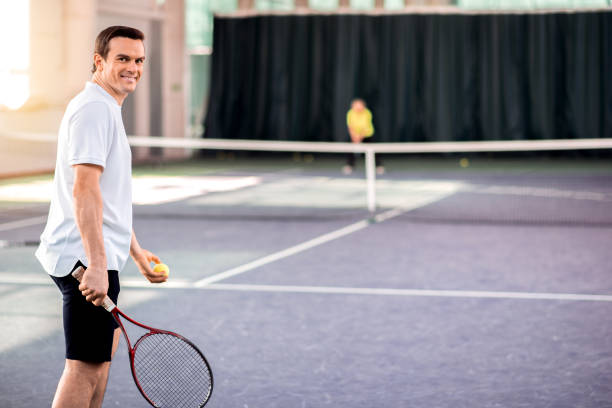 istock Cheerful guy enjoying tennis game 690880252