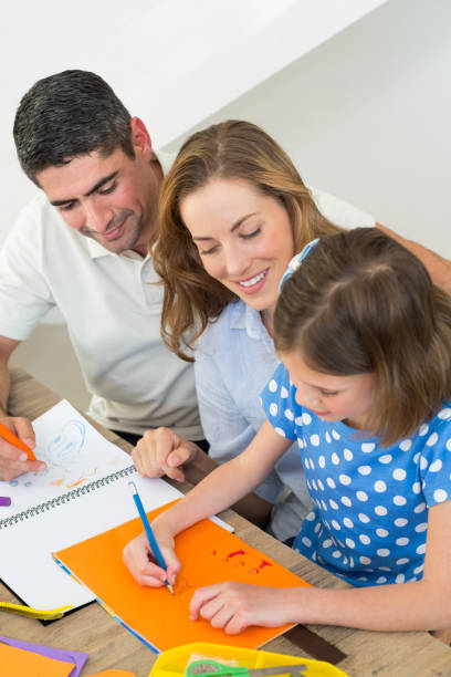 istock Parents looking at girl drawing 690882430