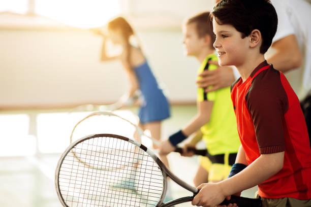 enfants excités, jouer au tennis sur cour - tennis child teenager childhood photos et images de collection