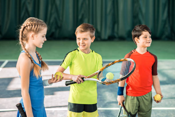 istock Happy children playing tennis on playground 690883152