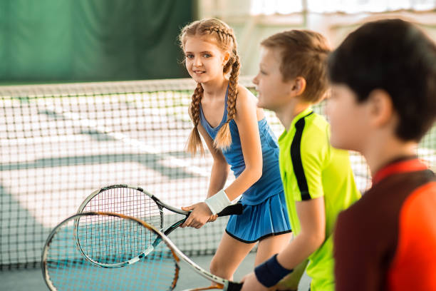 istock Joyful kids having fun on tennis court 690883316