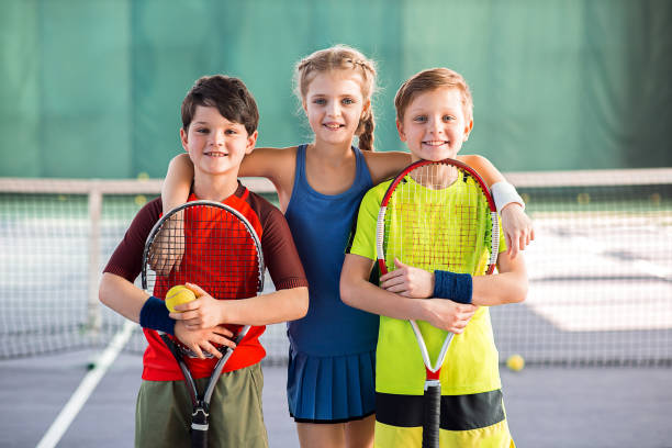 bambini allegri che si divertono sul campo da tennis - tennis child teenager childhood foto e immagini stock